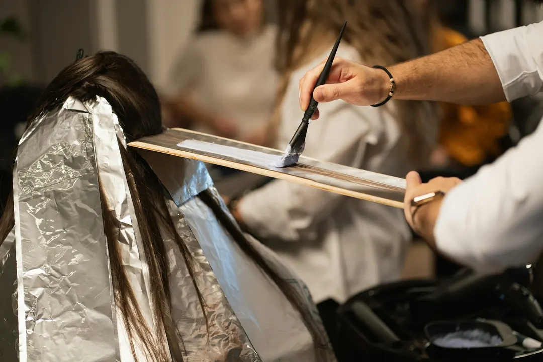 Ekspertka OU Beauty wykonująca precyzyjne rozjaśnianie techniką balayage farbami Leyton