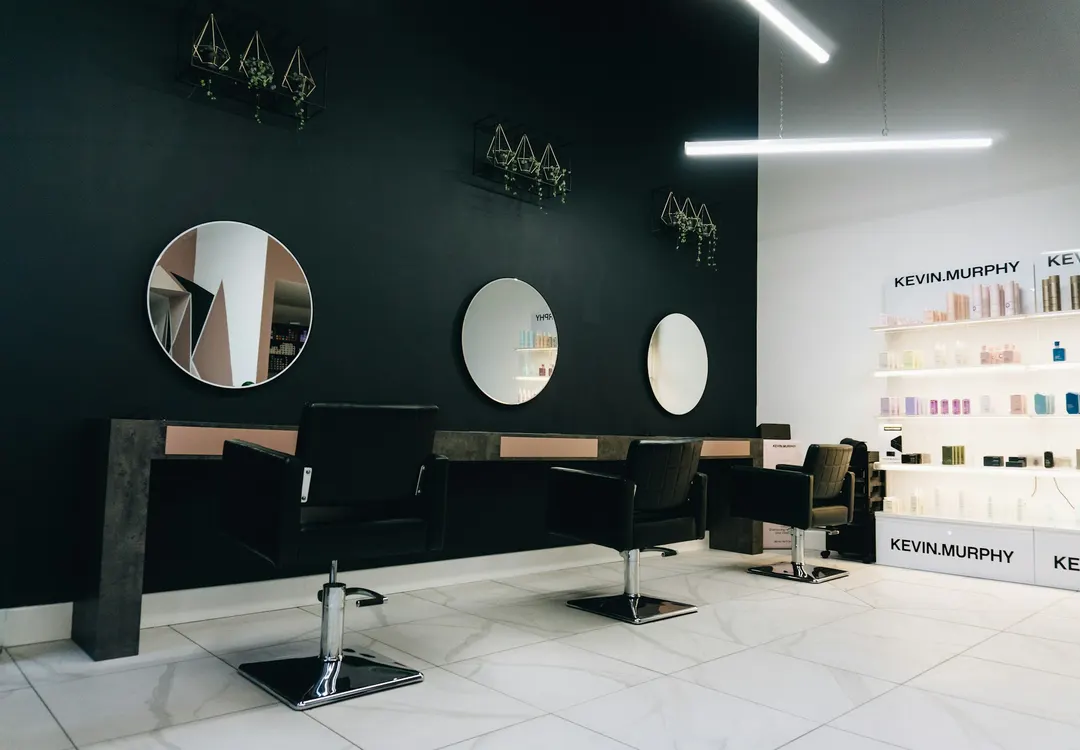 Eleganckie stanowiska z okrągłymi podświetlanymi lustrami w salonie OU Beauty we Wrocławiu